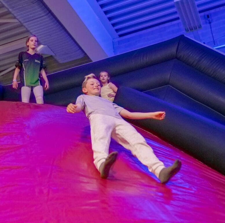 Child on Dare2Air sliding down the Volcano Slide