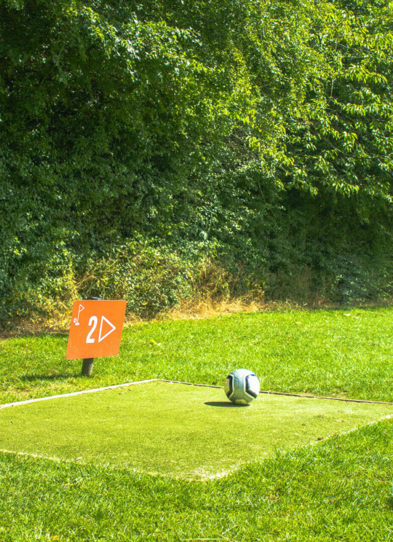 Man preparing to kick the football from the tee at Footgolf